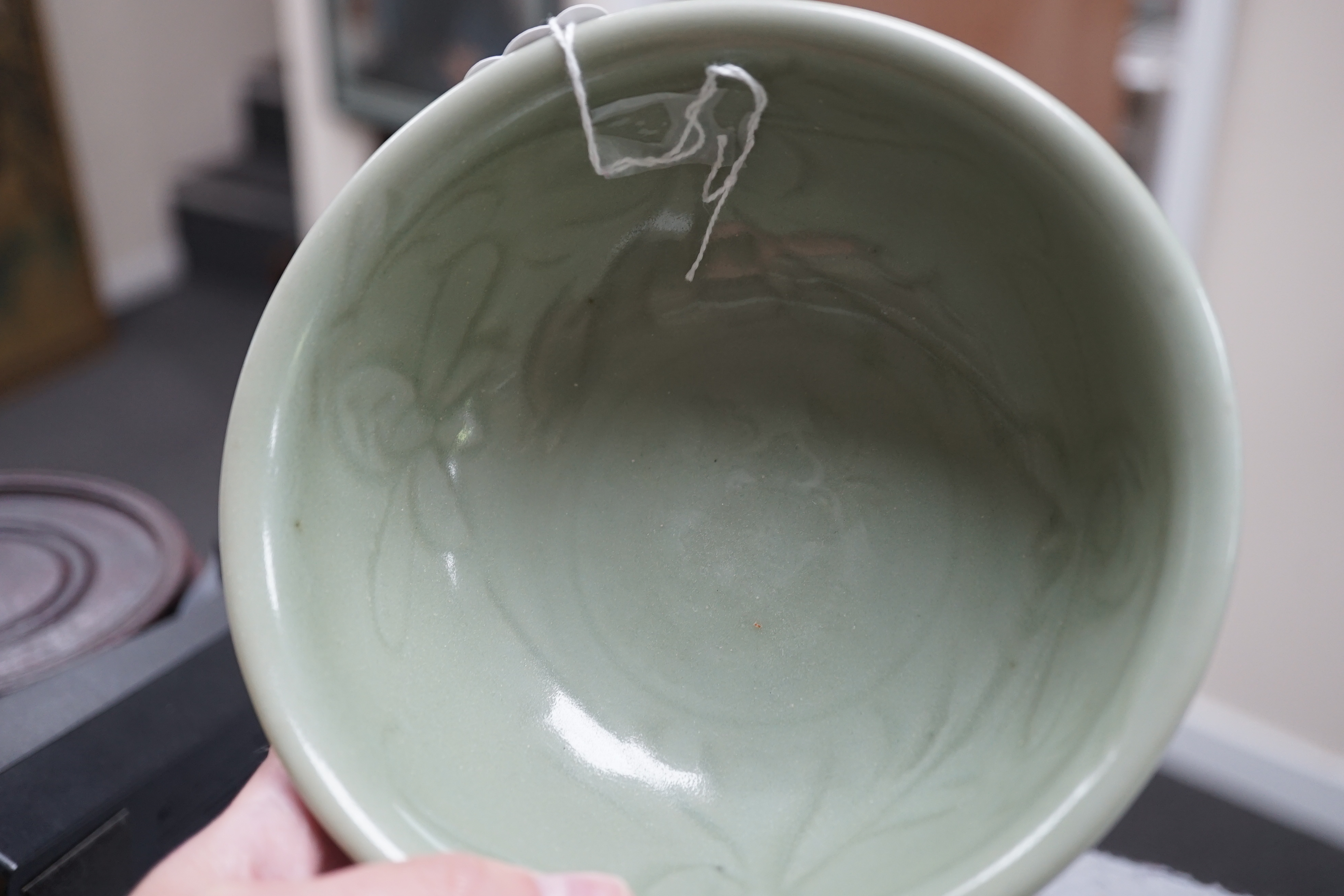 A Chinese Longquan celadon bowl, the interior carved with lotus flowers and the exterior with foliate lappets, 15.2cm diameter., Provenance - Robert Ricketts collection, formerly sold by Robert McPherson, London and S. M